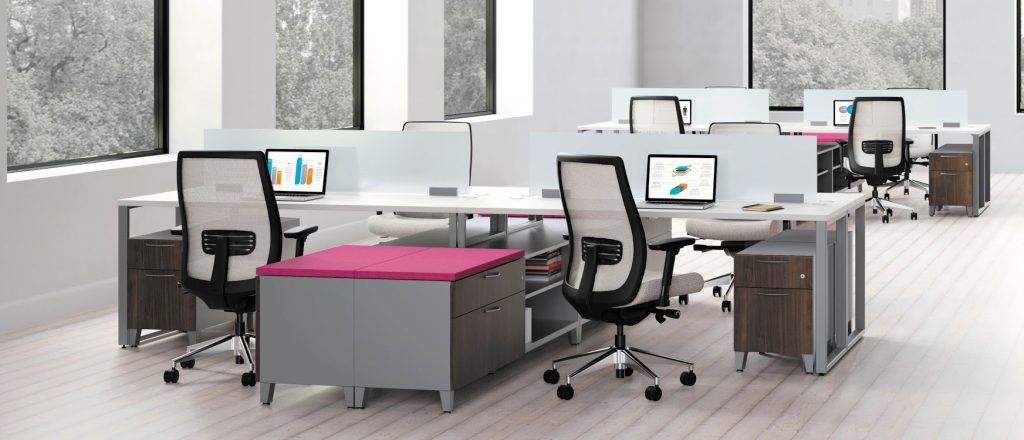 Images shows the HON Contain_Voi_Footed collaborative work space area. Image includes several example work spaces with vibrant filing cabinets and ergonomic desk chairs.