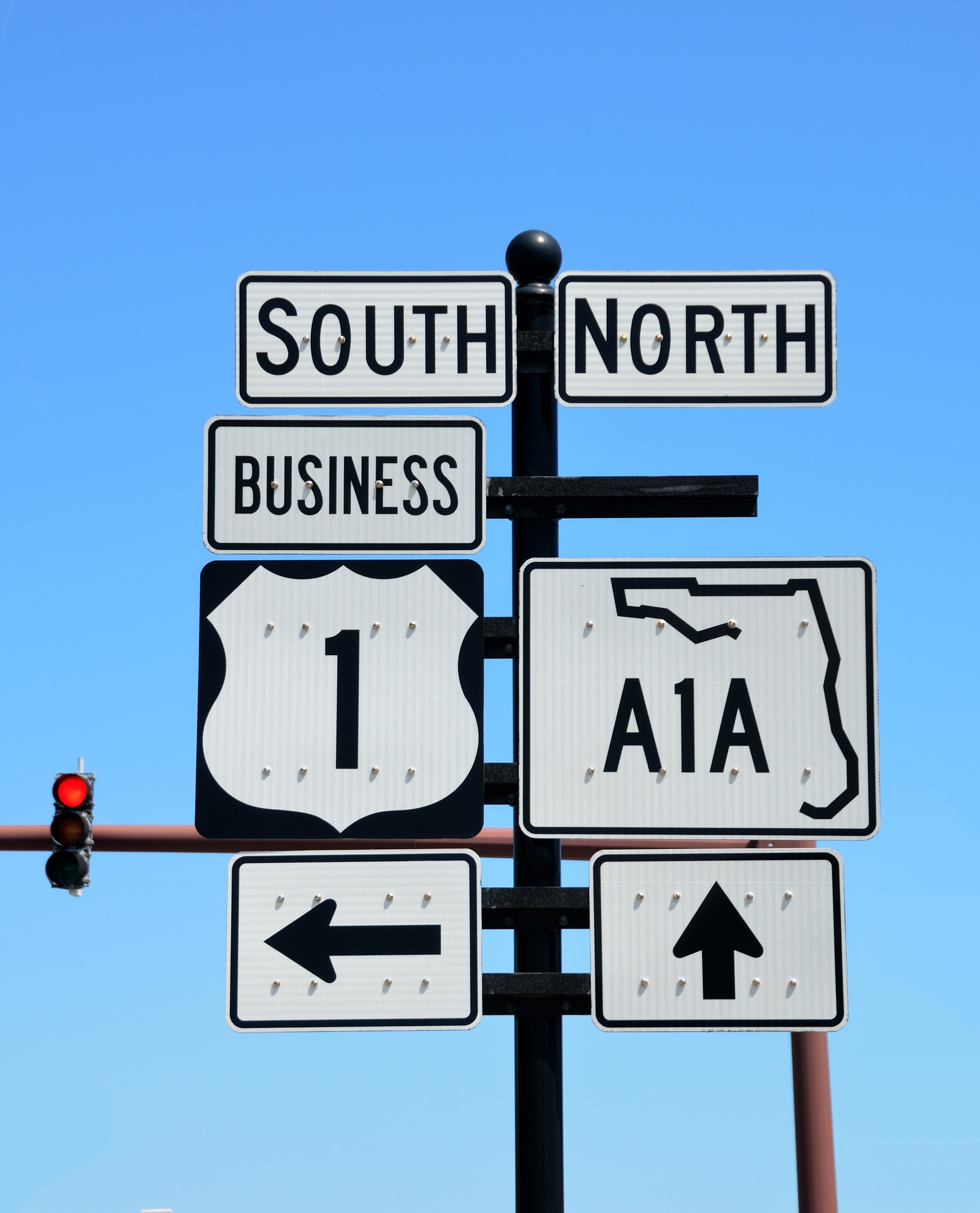 Image depicts a Street sign in Florida showing South Business US 1 and North A1A with arrows pointing to the correct direction depending on which way you are headed